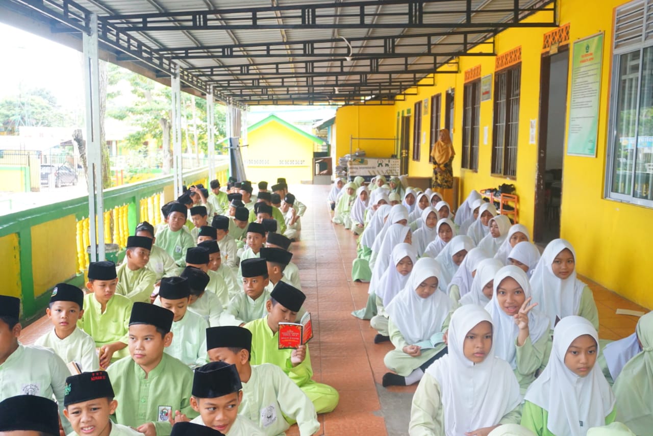 Siswa-siswi MI Raudlatul Qur’an Batam mengikuti kegiatan tadarus pagi bersama guru pembimbing di lingkungan madrasah.